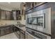 Kitchen with stainless steel appliances, dark wood cabinets, and tile backsplash and floor at 25155 N 108Th Ave, Peoria, AZ 85383