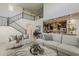 Open-concept living room with staircase and adjacent kitchen; neutral toned furniture and decor at 25155 N 108Th Ave, Peoria, AZ 85383