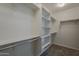 Walk-in closet featuring built-in shelving and ample storage space at 25155 N 108Th Ave, Peoria, AZ 85383