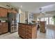 Kitchen with stainless steel refrigerator, island with granite countertops, and an eat-in dining space at 2984 N 152Nd Dr, Goodyear, AZ 85395