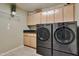 The laundry room features built-in cabinets, granite countertops, a shelf, and a washer and dryer at 2984 N 152Nd Dr, Goodyear, AZ 85395