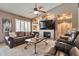 Bright living room featuring a fireplace, built-in shelving, plantation shutters, and comfortable seating at 2984 N 152Nd Dr, Goodyear, AZ 85395