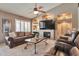 Bright living room featuring a fireplace, built-in shelving, plantation shutters, and comfortable seating at 2984 N 152Nd Dr, Goodyear, AZ 85395