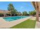 Beautiful backyard pool with manicured landscaping, palm trees, and an artificial turf area at 2984 N 152Nd Dr, Goodyear, AZ 85395