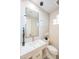 Modern bathroom with white vanity, decorative mirror and floating lights against marble accent wall at 3153 E Sierra Vista Dr, Phoenix, AZ 85016