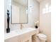 Modern powder room features white vanity, decorative mirror and floating lights against marble accent wall at 3153 E Sierra Vista Dr, Phoenix, AZ 85016