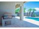 Outdoor kitchen with stainless steel grill next to swimming pool in private backyard oasis at 3153 E Sierra Vista Dr, Phoenix, AZ 85016