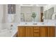 Well-lit bathroom featuring double sinks, a soaking tub, and modern fixtures at 35402 N 32Nd Dr, Phoenix, AZ 85086