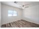 Simple bedroom featuring white walls, wood-look floors, a ceiling fan, and a window at 4065 E University Dr # 436, Mesa, AZ 85205