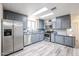 Modern kitchen with stainless steel appliances, gray cabinets, and light wood floors at 4065 E University Dr # 436, Mesa, AZ 85205
