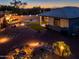 Aerial view highlighting a well-lit backyard, covered patio, and lush landscaping at 41793 W Canasta Ln, Maricopa, AZ 85138