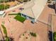 Aerial view of backyard with desert landscaping, fire pit, outdoor kitchen, and artificial grass at 41793 W Canasta Ln, Maricopa, AZ 85138