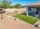 Stunning backyard features an outdoor kitchen, artificial grass, a fire pit, and desert landscaping at 41793 W Canasta Ln, Maricopa, AZ 85138