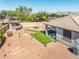 Backyard highlighting covered BBQ area, and artificial turf surrounded by desert landscaping at 41793 W Canasta Ln, Maricopa, AZ 85138
