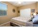 Bedroom features a patterned bedspread, wood-look tile flooring, closet with sliding doors, and a window at 41793 W Canasta Ln, Maricopa, AZ 85138