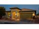 Front exterior of home with desert landscaping, two-car garage, and covered porch at 41793 W Canasta Ln, Maricopa, AZ 85138