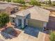Aerial view of home showcasing a two-car garage, covered porch, and desert landscaping at 41793 W Canasta Ln, Maricopa, AZ 85138