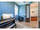 Bright blue room with piano, wooden floors, ceiling fan, a chair, and a window at 41793 W Canasta Ln, Maricopa, AZ 85138