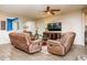 Inviting living room with tile floors, ceiling fan, comfortable recliner chairs, and a view to the office at 41793 W Canasta Ln, Maricopa, AZ 85138