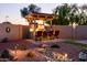 Entertain in style with this outdoor kitchen, complete with a built-in grill, bar seating, and cozy lighting at 41793 W Canasta Ln, Maricopa, AZ 85138