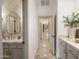 Hallway leading to a half bath with herringbone tile wall and decorative mirror and long view to end of hall at 4350 S White Dr, Chandler, AZ 85249
