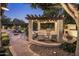 Outdoor kitchen and entertaining area featuring a grill, fireplace, and patio seating, with a pool in the background at 4350 S White Dr, Chandler, AZ 85249