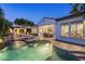 Stunning backyard pool with fountains, lounge chairs, and a covered outdoor kitchen area, lit beautifully at dusk at 4350 S White Dr, Chandler, AZ 85249