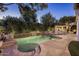 A backyard oasis featuring a freeform pool with fountains, lush greenery, and an outdoor kitchen with a fireplace at 4350 S White Dr, Chandler, AZ 85249