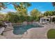 Beautiful backyard pool area with stone features, flowing water, elegant patio furniture, and mature landscaping at 4350 S White Dr, Chandler, AZ 85249