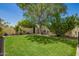 Expansive backyard boasts lush lawn, mature shade trees, manicured landscaping, and privacy fencing at 5350 S River Dr, Tempe, AZ 85283
