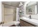 Bathroom features updated vanity, mirror, tub/shower, and storage shelving at 5350 S River Dr, Tempe, AZ 85283