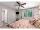Comfortable bedroom with patterned bedding, neutral walls, and a large window for natural light at 5350 S River Dr, Tempe, AZ 85283
