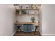 This home office features a built-in desk with stylish decor, shelves and dark wood floors at 5350 S River Dr, Tempe, AZ 85283