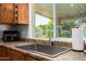 Close-up of the kitchen sink with a view to the landscaped backyard at 5350 S River Dr, Tempe, AZ 85283
