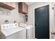 Functional laundry room equipped with washer, dryer, and overhead cabinets at 5350 S River Dr, Tempe, AZ 85283