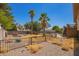 Fenced backyard featuring desert landscaping, palm trees, and a wooden deck attached to the house at 7259 E Glencove St, Mesa, AZ 85207