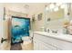 Comfortable bathroom featuring a white single sink vanity and shower with ocean themed curtain at 7259 E Glencove St, Mesa, AZ 85207