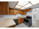 Efficient kitchen with wooden cabinets, light countertops, and stainless steel appliances at 8314 N 21St Dr # K208, Phoenix, AZ 85021