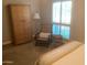 Bedroom with comfortable chair, woven cabinet, and light filtering through white shutters at 1036 E Wagon Wheel Dr, Phoenix, AZ 85020