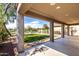 A covered patio view of the artificial turf backyard and desert landscaping at 10830 W El Cortez Pl, Peoria, AZ 85383
