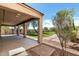 Covered patio overlooking backyard artificial turf with trees, bushes, and desert landscaping at 10830 W El Cortez Pl, Peoria, AZ 85383