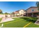Artificial turf backyard with desert landscaping, fire pit, and privacy wall at 10830 W El Cortez Pl, Peoria, AZ 85383