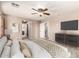 Staged bedroom with neutral walls, carpeted floor, television, and stairs view at 10830 W El Cortez Pl, Peoria, AZ 85383