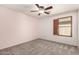 A bedroom features carpeted floors, ceiling fan, and window with wooden shutters at 10830 W El Cortez Pl, Peoria, AZ 85383