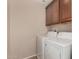 Bright laundry room features full-size washer and dryer and upper cabinets at 10830 W El Cortez Pl, Peoria, AZ 85383