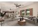 Open living area showcasing a large sectional, ceiling fans, and seamless access to the kitchen at 10830 W El Cortez Pl, Peoria, AZ 85383