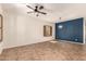 Neutral-toned living room featuring ceramic tile flooring, a ceiling fan, and shuttered windows at 10830 W El Cortez Pl, Peoria, AZ 85383