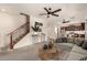 Open living room featuring a staircase, ceiling fans, and modern decor at 10830 W El Cortez Pl, Peoria, AZ 85383