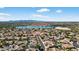 Wide aerial shot showcasing community homes with tile roofs, solar panels, and a beautiful lake in the distance at 10897 S Turtle Dove S Dr, Goodyear, AZ 85338