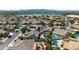 Picturesque aerial view showcasing community homes, pools, and a scenic lake against a mountain backdrop at 10897 S Turtle Dove S Dr, Goodyear, AZ 85338